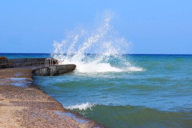 Deniz su fırtına dalgaları isabet taş iskele, rüzgarlı ve güneşli gün