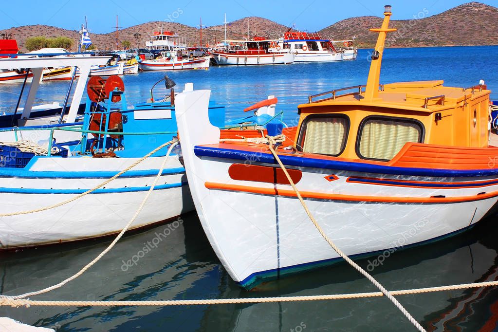 Greek fishing boats are moored at city port.