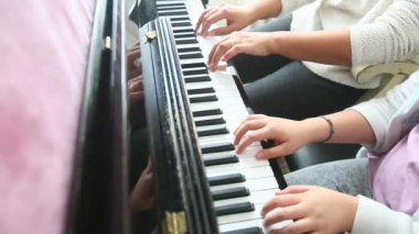 Bir müzik öğretmeni piyano öğrencisi öğretir.