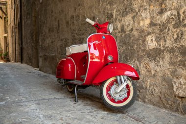 30 Haziran 2019 - Roma, Lazio, İtalya - İtalya 'da antik bir köyün ara sokaklarında park edilmiş kırmızı bir Piaggio Vespa Sprint. İtalyan tasarımının scooter sembolü.