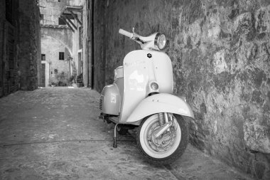 30 Haziran 2019 - Roma, Lazio, İtalya - İtalya 'da antik bir köyün ara sokaklarında park edilmiş beyaz bir Piaggio Vespa Sprint. İtalyan tasarımının scooter sembolü.