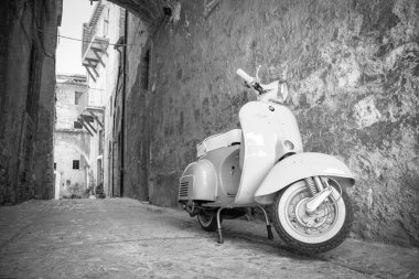 30 Haziran 2019 - Roma, Lazio, İtalya - İtalya 'da antik bir köyün ara sokaklarında park edilmiş beyaz bir Piaggio Vespa Sprint. İtalyan tasarımının scooter sembolü.