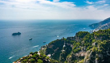 Bir yolcu gemisi gün batımında Ravello 'daki Amalfi sahilinin önünden geçiyor. Denize bakan evleri olan küçük köyler. İtalya, Campania, Salerno 'da.