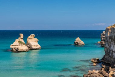 Torre dell 'Orso körfezi, yüksek uçurumları, Salento, Puglia, İtalya. Turkuaz deniz ve mavi gökyüzü, yazın güneşli bir gün. 