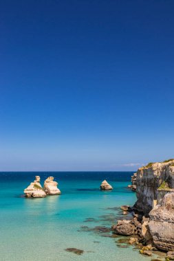 Torre dell 'Orso körfezi, yüksek uçurumları, Salento, Puglia, İtalya. Turkuaz deniz ve mavi gökyüzü, yazın güneşli bir gün. 