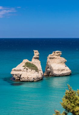 Torre dell 'Orso körfezi, yüksek uçurumları, Salento, Puglia, İtalya. Turkuaz deniz ve mavi gökyüzü, yazın güneşli bir gün. 