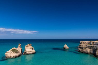 Torre dell 'Orso körfezi, yüksek uçurumları, Salento, Puglia, İtalya. Turkuaz deniz ve mavi gökyüzü, yazın güneşli bir gün. 