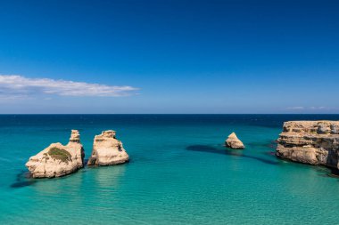 Torre dell 'Orso körfezi, yüksek uçurumları, Salento, Puglia, İtalya. Turkuaz deniz ve mavi gökyüzü, yazın güneşli bir gün. 