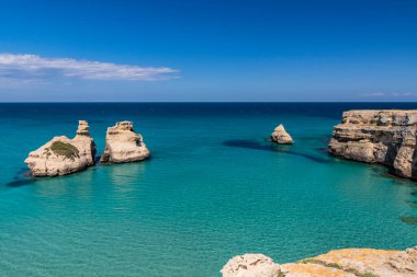 Torre dell 'Orso körfezi, yüksek uçurumları, Salento, Puglia, İtalya. Turkuaz deniz ve mavi gökyüzü, yazın güneşli bir gün. 