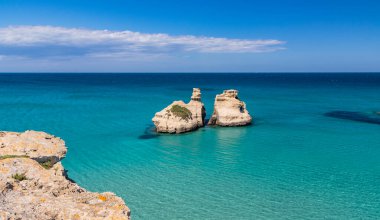 Torre dell 'Orso körfezi, yüksek uçurumları, Salento, Puglia, İtalya. Turkuaz deniz ve mavi gökyüzü, yazın güneşli bir gün. 