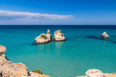 Torre dell 'Orso körfezi, yüksek uçurumları, Salento, Puglia, İtalya. Turkuaz deniz ve mavi gökyüzü, yazın güneşli bir gün. 
