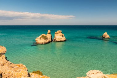 Torre dell 'Orso körfezi, yüksek uçurumları, Salento, Puglia, İtalya. Turkuaz deniz ve mavi gökyüzü, yazın güneşli bir gün. 