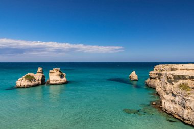 Torre dell 'Orso körfezi, yüksek uçurumları, Salento, Puglia, İtalya. Turkuaz deniz ve mavi gökyüzü, yazın güneşli bir gün. 