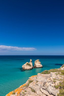 Torre dell 'Orso körfezi, yüksek uçurumları, Salento, Puglia, İtalya. Turkuaz deniz ve mavi gökyüzü, yazın güneşli bir gün. 