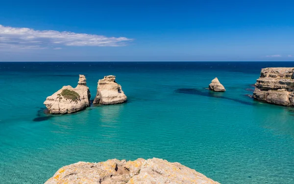 Torre dell 'Orso körfezi, yüksek uçurumları, Salento, Puglia, İtalya. Turkuaz deniz ve mavi gökyüzü, yazın güneşli bir gün. 
