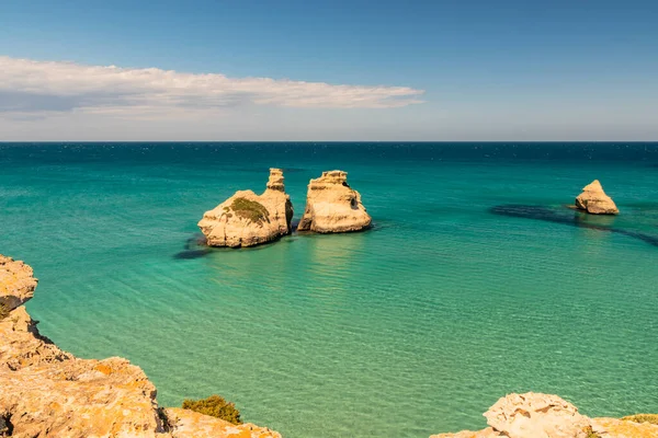 Torre dell 'Orso körfezi, yüksek uçurumları, Salento, Puglia, İtalya. Turkuaz deniz ve mavi gökyüzü, yazın güneşli bir gün. 