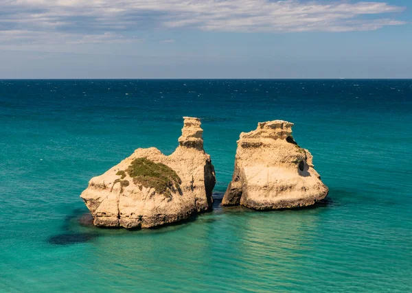 意大利普利亚萨莱托的托尔 德尔奥索海湾 其悬崖很高 碧绿的大海和蓝天 夏日阳光灿烂 被称为 两姐妹 的堆栈沉入大海 — 图库照片