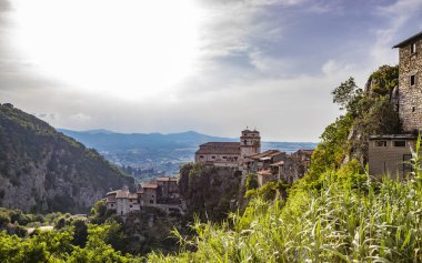 Eski Artena köyünden Sacco Nehri Vadisi manzarası. Kasaba dağa tünedi. Uçurumun tepesinde, Santa Croce Kilisesi. Ağaçlar ve yoğun bitki örtüsü. Gün batımında. 
