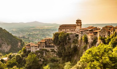Eski Artena köyünden Sacco Nehri Vadisi manzarası. Kasaba dağa tünedi. Uçurumun tepesinde, Santa Croce Kilisesi. Ağaçlar ve yoğun bitki örtüsü. Gün batımında. 
