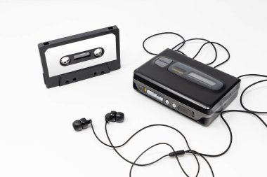 Klasik ses oynatıcı. Eski moda kaset çalar, tarikat objesi, 80 'ler ve 90' ların simgesi. Beyaz arkaplanda boş ses bandı ve kulaklık izole edildi.