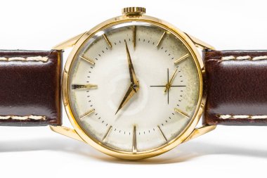 Elle kumandalı eski bir altın mekanik kol saati. Zaman tarafından mahvedilmiş antika saat, çizikler, küf lekeleri, pas, oksitlenme. Deri kayış (bant). Klasik saat. Zaman geçir.