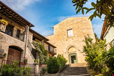 Ortaçağ köyü Bevagna 'daki antik kiliselerden biri. Perugia, Umbria, İtalya. Çiçekli balkonlu tuğla ve taş evler..