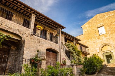 Ortaçağ köyü Bevagna 'daki antik kiliselerden biri. Perugia, Umbria, İtalya. Çiçekli balkonlu tuğla ve taş evler..