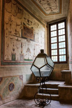3 Haziran 2016 - Caprarola, Viterbo, Lazio, İtalya - Villa Farnese, bir Rönesans ve Mannerist yapı. Binanın içinde boyanmış güzel fresklerden biri. Pencerenin yanındaki antik lamba.