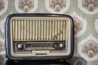 1 Mart 2020 - Roma, İtalya - Telefunken Mignonette, eski bir transistör radyo, manuel ayarlama için düğmeleri ve düğmeleri var. Arka planda eski bir duvar kağıdı var. Zaman tarafından yıpranmış ve yıpranmış eski bir nesne..