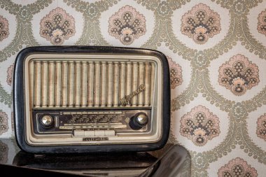 1 Mart 2020 - Roma, İtalya - Telefunken Mignonette, eski bir transistör radyo, manuel ayarlama için düğmeleri ve düğmeleri var. Arka planda eski bir duvar kağıdı var. Zaman tarafından yıpranmış ve yıpranmış eski bir nesne..