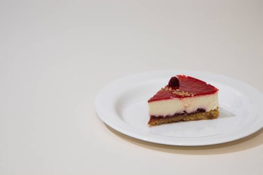 Beyaz tabakta bir dilim cheesecake. Beyaz arkaplanda izole.
