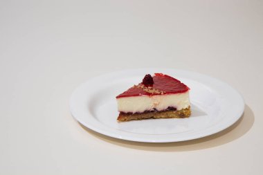 Beyaz tabakta bir dilim cheesecake. Beyaz arkaplanda izole.