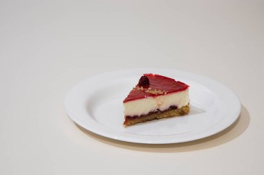 Beyaz tabakta bir dilim cheesecake. Beyaz arkaplanda izole.
