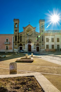 San Domenico Kilisesi, hububat kuyularının yanındaki Granarie Fosse 'un planı. Mısır gevreği depolamak için eski taş silolar. Binanın arkasındaki güneşin göz kamaştırıcı parlaklığı. Cerignola, Puglia, İtalya.