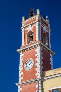 Saat kulesi, beyaz tuğlalı kırmızı. Bina 19. yüzyıla dayanıyor. Ziller üstte. Cerignola, Puglia, İtalya.