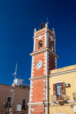 Saat kulesi, beyaz tuğlalı kırmızı. Bina 19. yüzyıla dayanıyor. Demir sokak lambası özgürlük tarzında. Cerignola, Puglia, İtalya. Güvenlik kameraları. 
