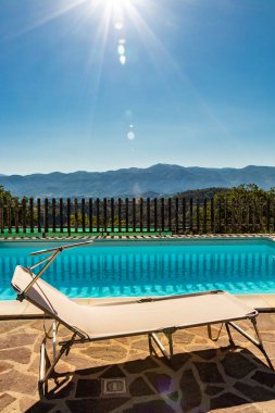 Yazın, sabah güneşiyle dağlarda inanılmaz bir yüzme havuzu. Rahatlama, tatil, lüks, dinlenme, tatil, boş zaman kavramı. Fenerli ve ışıltılı bir sahne..