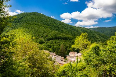 Trinci kalesinin tepesinden görünen Rasiglia 'nın küçük köyü. Dağ manzarası, bitki ve ağaçlarla dolu. Yazın mavi gökyüzü. Eski tuğla evler. Foligno, Umbria, İtalya
