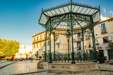 27 Ekim 2019 - Isernia, Molise, İtalya - Şehir merkezindeki terk edilmiş meydan. Akşamları barların ve restoranların boş masaları. Özgürlük stili yeşil işlemeli demir çardak (Art Nouveau)