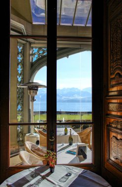 8 Ocak 2015 - Thun, Bern, İsviçre - Schadau Kalesi 'nin içindeki lüks restorana yakın çekim, gölün (pencereden) muhteşem manzarası ve karla kaplı dağlarla