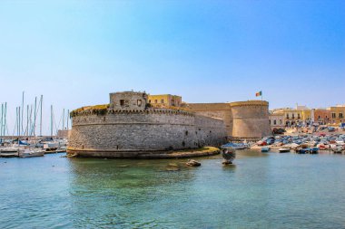 Denize bakan kale, İtalya 'nın Puglia kentindeki Gelibolu kasabasında. Gemiler demirledi. Mavi gökyüzü.