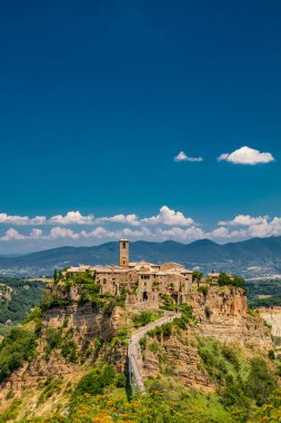 Çorak Topraklar Vadisi 'nin ortasındaki Tuff Kayası' nın tepesindeki Ortaçağ kasabası Civita di Bagnoregio. Şehre küçük bir köprü ve katır yolu ile bağlandı.. 
