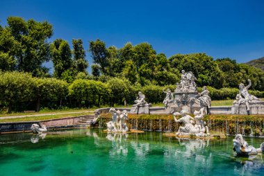 3 Temmuz 2020 - Caserta Kraliyet Sarayı - Mermer heykeller, şelaleler ve su manzaralı büyük çeşme. Yazın mavi gökyüzü. Büyük otobüste balık var..