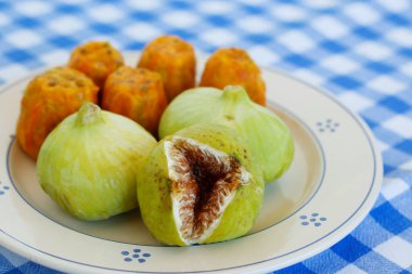 Salento 'da kahvaltı, güney İtalya geleneğinin tipik ürünleri: dikenli armutlar, incirler ve seramik tabaklara krema sürülmüş Pasticciotto ve beyaz ve mavi masa örtüsü.. 