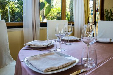 Bir İtalyan restoranında tören için masa hazır. Bir düğün için kutlama var. Şampanya dolu bir sepet. Çiçek süslemeleri. Pembe masa örtüsü. Lüks, zarafet, zarafet..