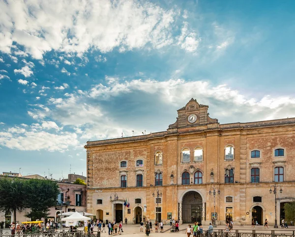 8 Ağustos 2020 - Matera, Basilicata, İtalya - Palazzo dell 'Annunziata, Piazza Vittorio Veneto' da 18. yüzyıl sarayı. Birçok turist bir yaz akşamı meydanda dolaşır..