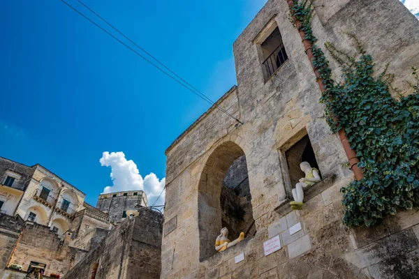 8 Ağustos 2020 - Matera, Basilicata, İtalya - Sassi 'deki Matera kasabasının tipik taş ve tuğla evleri. Margherita Grasselli 'nin heykelleri şehrin sokaklarını genişletiyor.