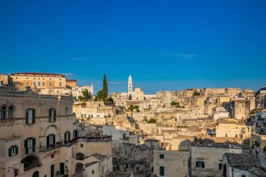 Matera, Basilicata, İtalya - Matera Sassisinin panoramik görüşü, Caveoso. Kayalara oyulmuş taş ve tuğladan eski evler. Arka plandaki katedral..