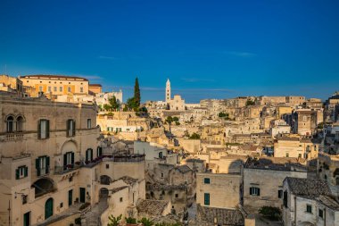 Matera, Basilicata, İtalya - Matera Sassisinin panoramik görüşü, Caveoso. Kayalara oyulmuş taş ve tuğladan eski evler. Arka plandaki katedral..