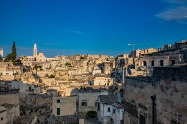 Matera, Basilicata, İtalya - Matera Sassisinin panoramik görüşü, Caveoso. Kayalara oyulmuş taş ve tuğladan eski evler. Arka plandaki katedral..